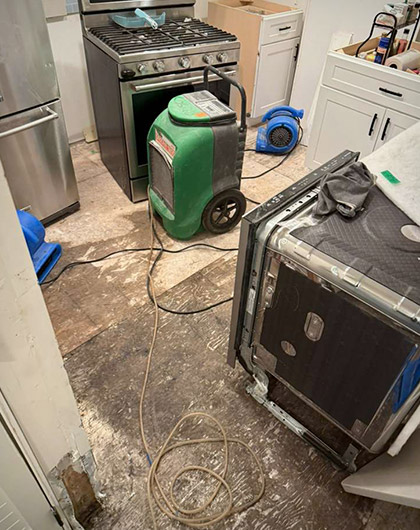 Dehumidifier and air mover drying the kitchen after water damage